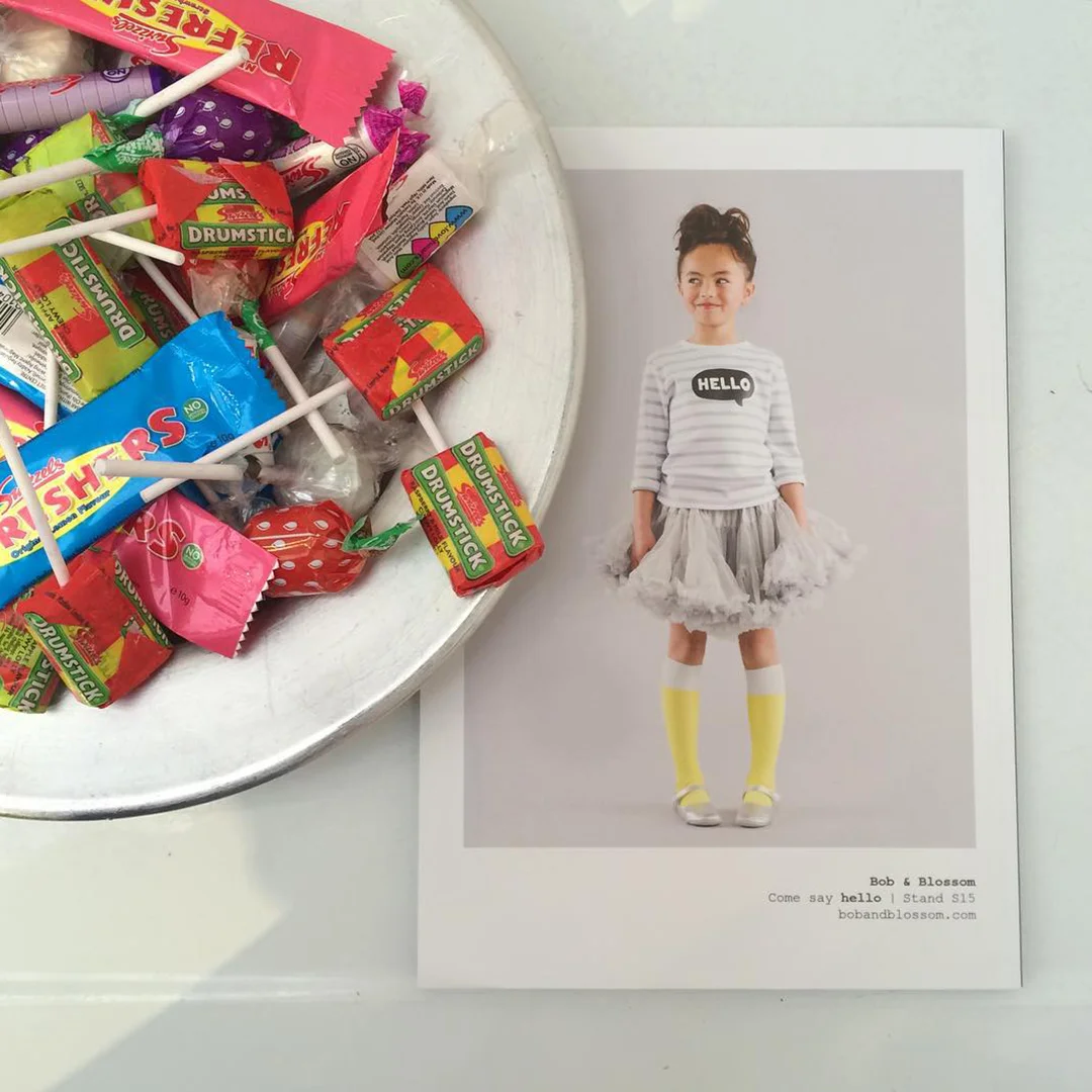 a Bob & Blossom promotional postcard next to a bowl of sweets
