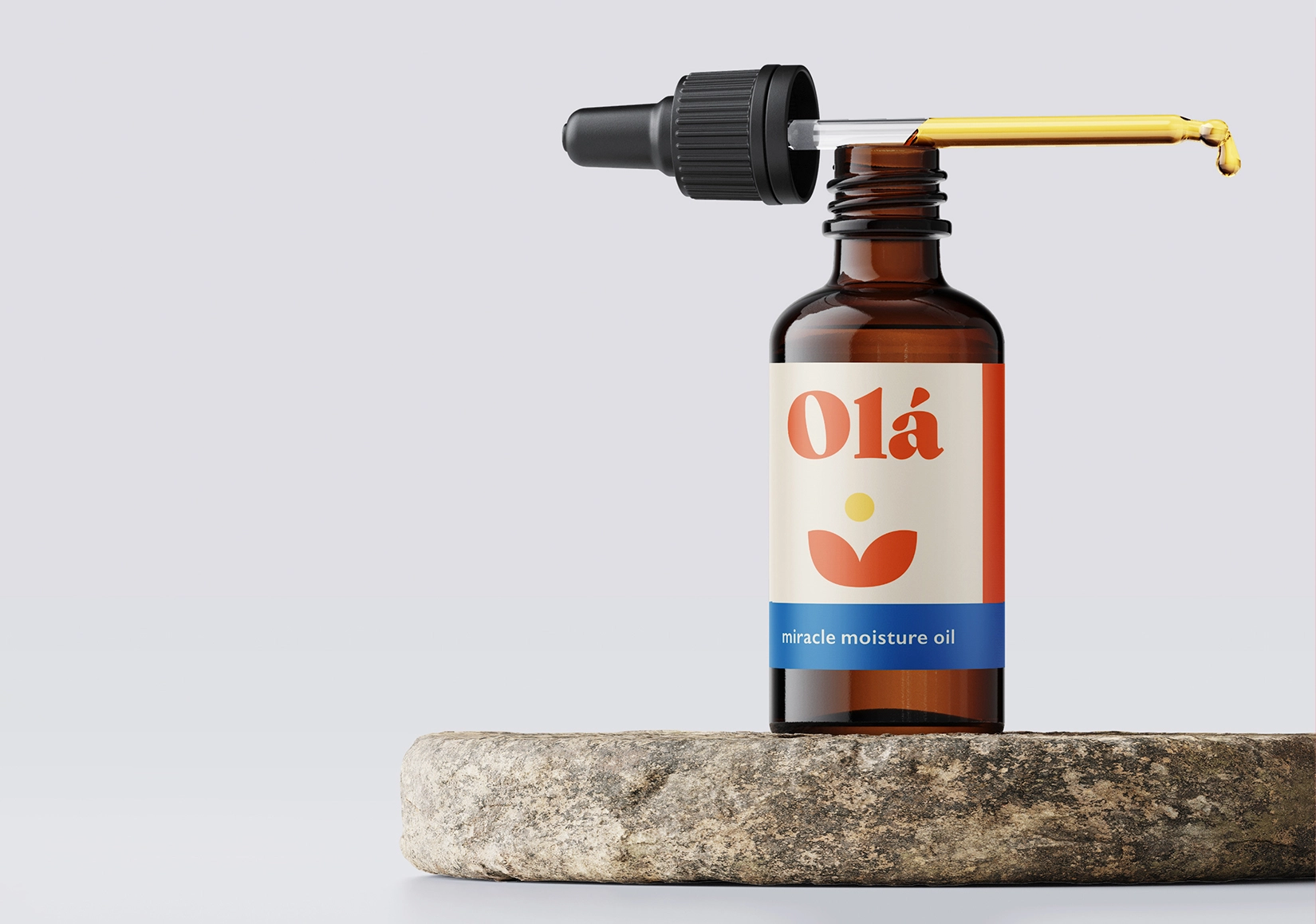 a bottle of the colourful Ola Miracle Moisture Oil on a round stone